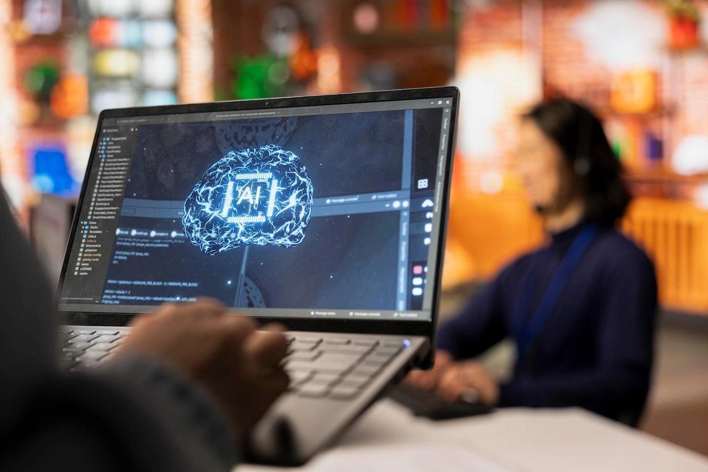 A developer at MVP Ventures Pty Ltd working on an AI agent project, displaying a laptop screen with a glowing digital brain graphic labeled "AI" alongside code repositories.